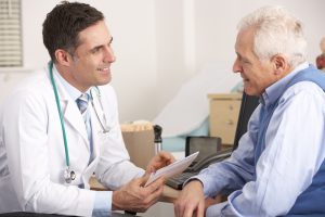 Implant dentist discussing treatment with senior man